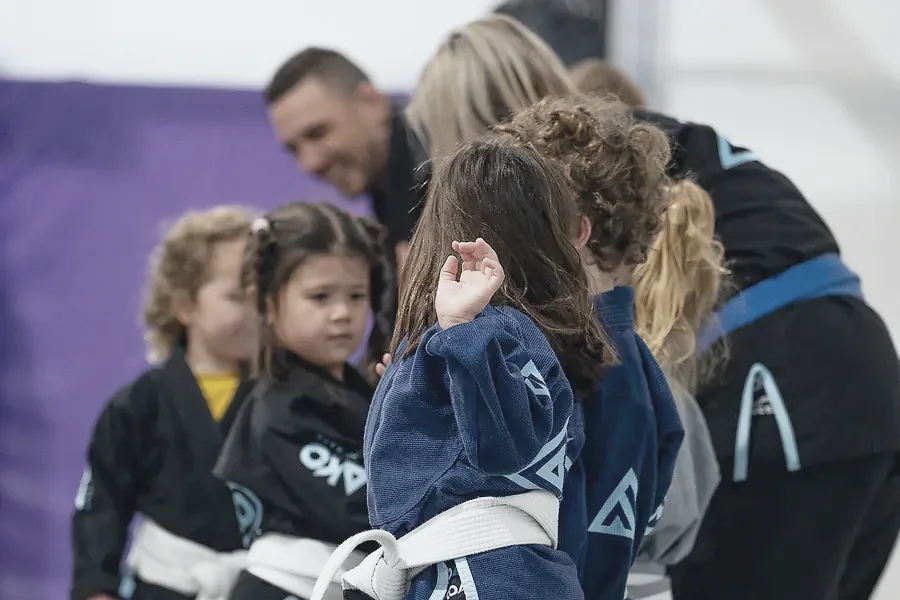 Two small children in gis facing off on the mats