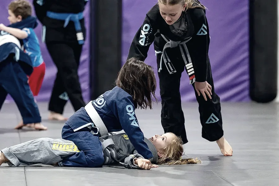 Kids practising a technique together on the mats