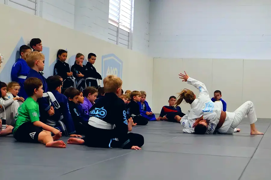 Two children sparring while the group watches safely