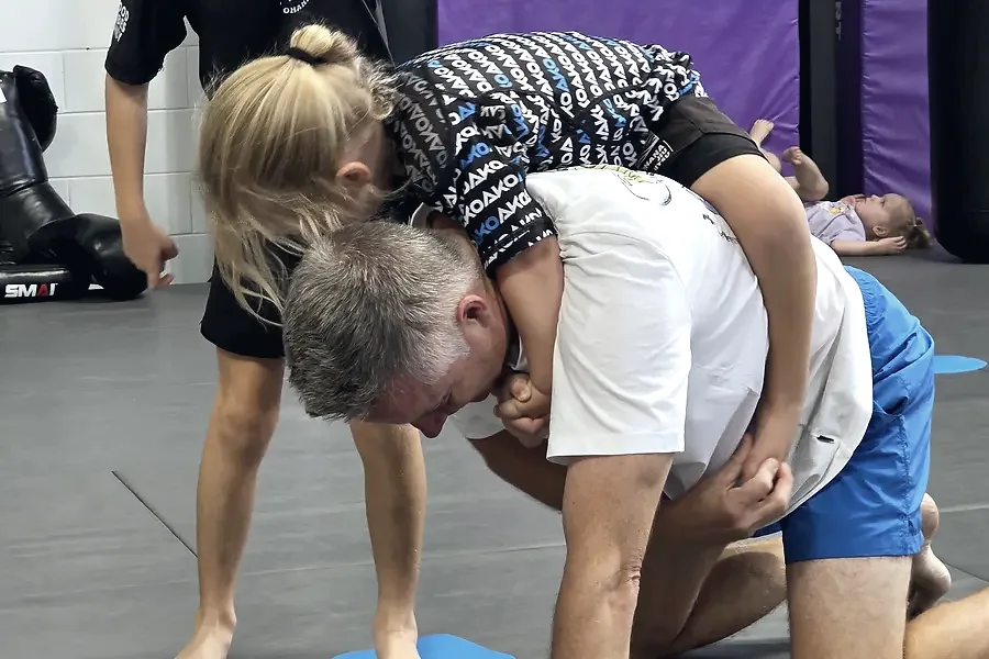 Two adults rolling during live training