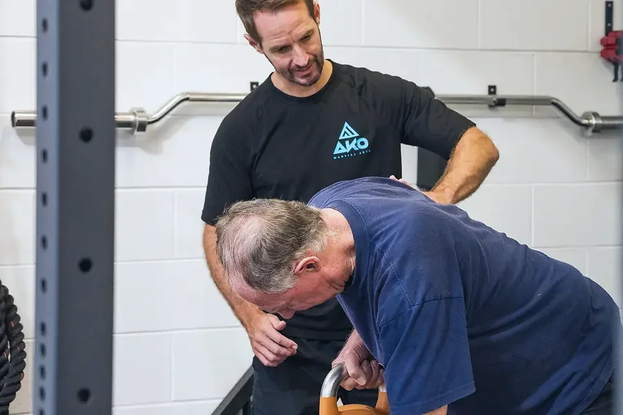 A coach working through a technique with an older student