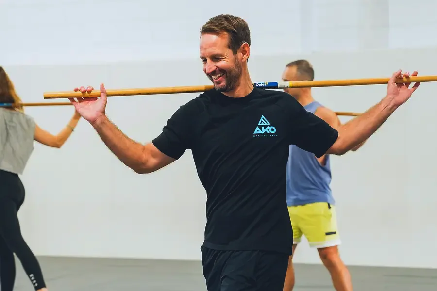 Adult men and women training together in a mobility class at Ako Martial Arts